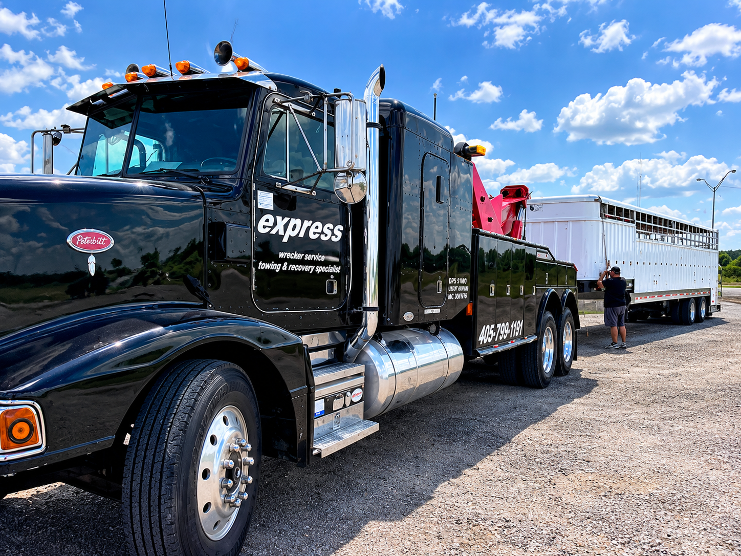 Express Wrecker Service black heavy-duty wrecker truck with a white trailer